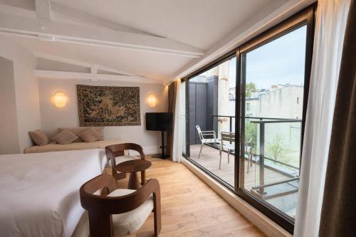 a hotel room with a bed and a balcony at Neuilly Park Hotel in Neuilly-sur-Seine