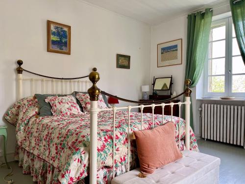 a bedroom with a bed with a floral bedspread at Chez Lapage in Saint-Avit-Sénieur