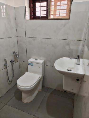 a bathroom with a toilet and a sink at Basuri Beach Resort in Varkala
