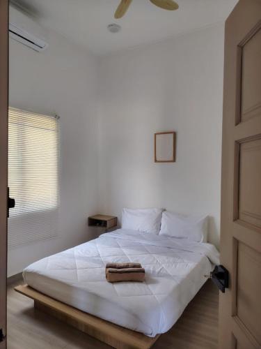 a white bed in a room with a window at Bayu Beach House in Cherating