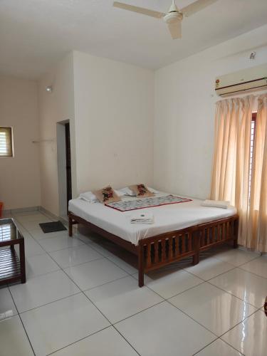 a bedroom with a bed in the middle of a room at Basuri Beach Resort in Varkala