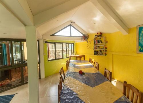 a group of tables in a room with yellow walls at Merlin Guest House in Rodrigues Island