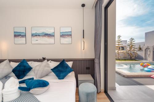 a living room with a couch and a swimming pool at Baby Blue pool villa in Ban Bo Prakhon