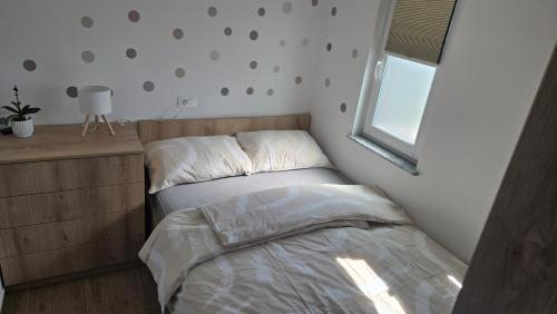a small bedroom with a bed and a window at Mountain Paradise Apartment in Zgornje Gorje