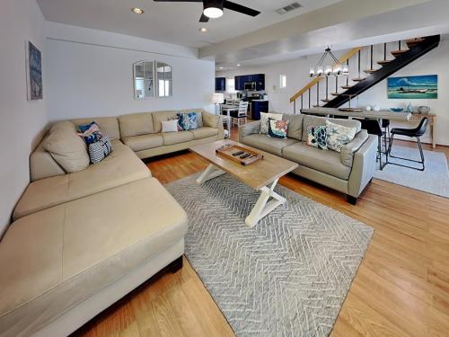 a living room with a couch and a table at Pool Days and Dock Nights in Galveston