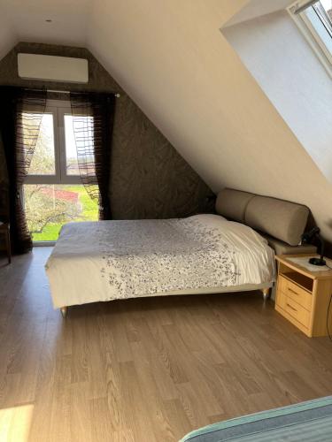 a bedroom with a bed and a wooden floor at Elsasslogie im Winzerdorf in Cleebourg