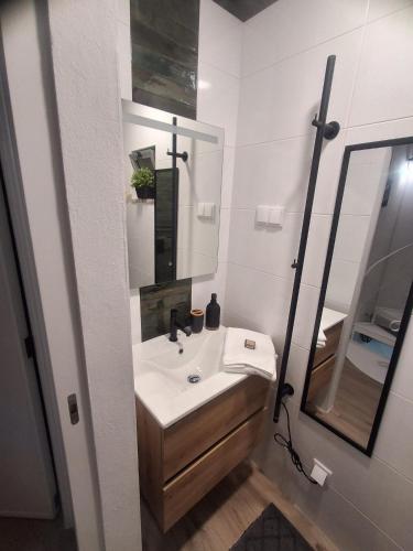 a white bathroom with a sink and a mirror at OrlaBela in Manta Rota