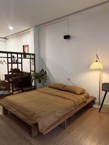 a large bed in a room with a lamp at Ceilé Stay Đà Lạt in Da Lat
