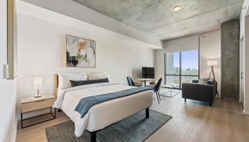 a bedroom with a bed and a desk with a chair at Sentral Forme Houston in Houston