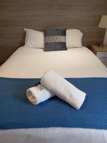 a bed with two towels laying on it at Shooters Hill Stay in London