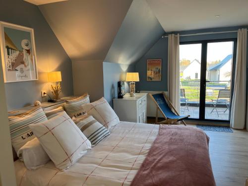 a bedroom with a large bed and a balcony at Au pré des chants in Saint-Philbert-des-Champs