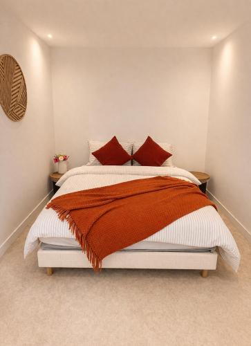 a bedroom with a large bed with red pillows at Logement accueillant in Gaillon