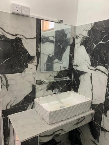 a bathroom with a sink and a marble wall at Sansa HomeStay in Bandarawela