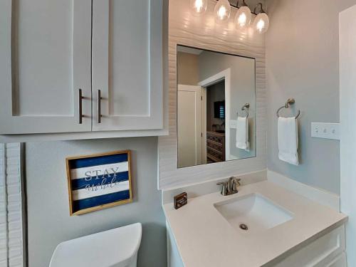 a white bathroom with a sink and a mirror at All Decked Out in Padre Island