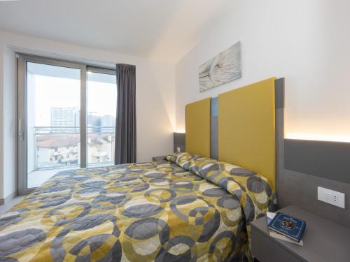 a bedroom with a bed and a large window at Modern flat in Piazza Fontana in Lignano Sabbiadoro