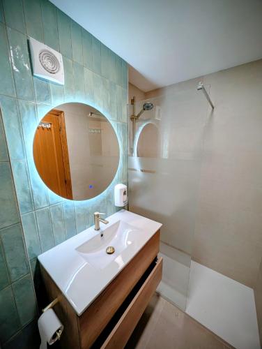 a bathroom with a sink and a mirror and a shower at Alojamiento La Ballena in Santoña