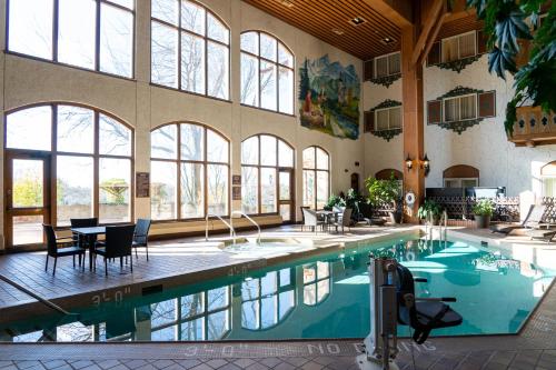 a large swimming pool with a table and chairs in a building at Bavarian Inn Lodge in Frankenmuth