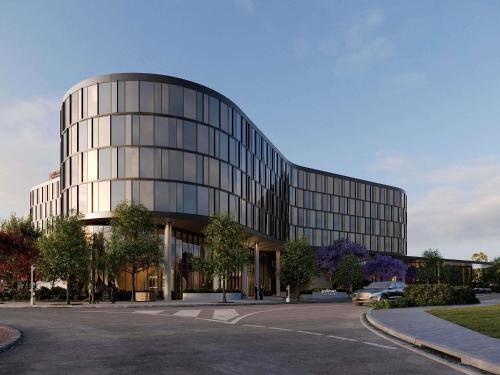 a large glass building with a car parked in front of it at Pullman Sydney Penrith in Penrith