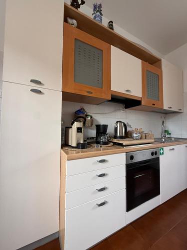 a kitchen with white cabinets and a stove top oven at B&B Il Balcone Fiorito in Imola