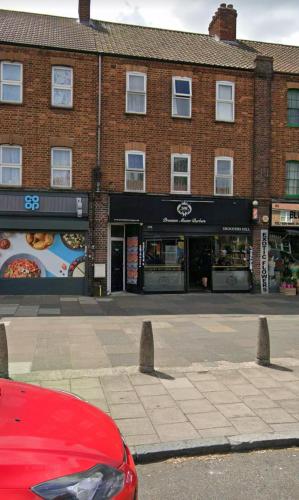 a red car parked in front of a brick building at Shooters Hill Stay in London