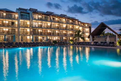a hotel with a swimming pool at night at El Beso Adults Only at Ocean Riviera Paradise All Inclusive in Playa del Carmen