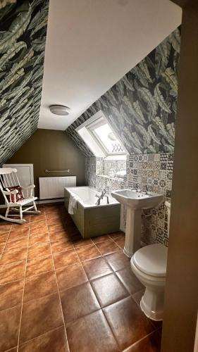 a bathroom with a toilet and a tub and a sink at Aynetree Guest House in Edinburgh