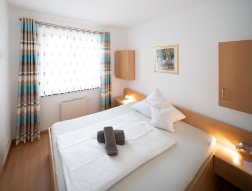 a white bed in a room with a window at Ferienwohnung am Moselufer in Cochem