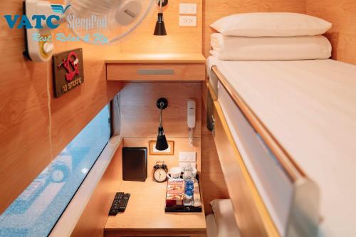 a small room with a bed and a desk at VATC Sleep Pod Terminal 2 in Noi Bai