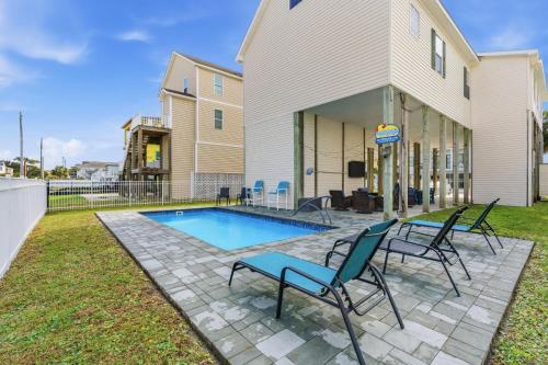 a patio with chairs and a pool in front of a building at Antigua Breeze - 3rd Row - Windy Hill Section in Myrtle Beach