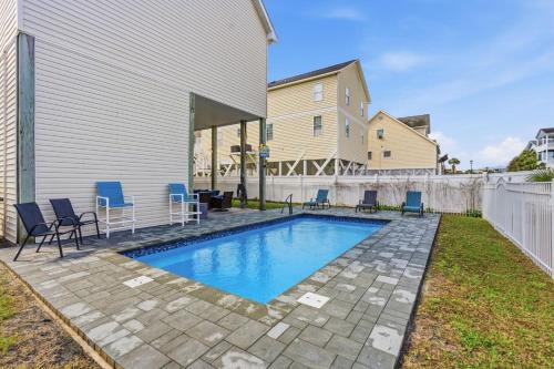a swimming pool in a backyard with chairs around it at Antigua Breeze - 3rd Row - Windy Hill Section in Myrtle Beach
