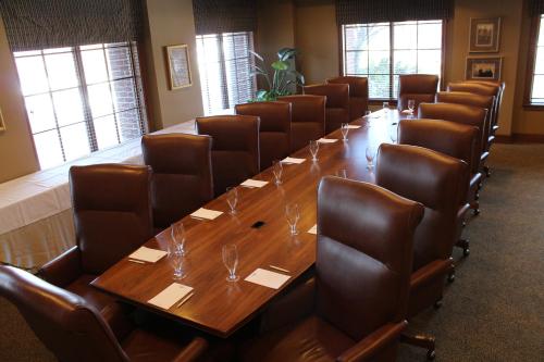 a conference room with a long wooden table and chairs at The Glen Club in Glenview