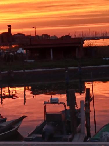 Eine Person, die bei Sonnenuntergang im Wasser steht in der Unterkunft Venice lagoon suite in Chioggia