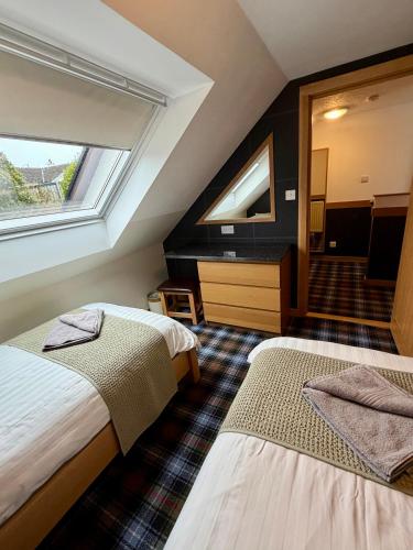 a hotel room with two beds and a window at Misty Isle Apartments Ltd - Maol View in Kyleakin