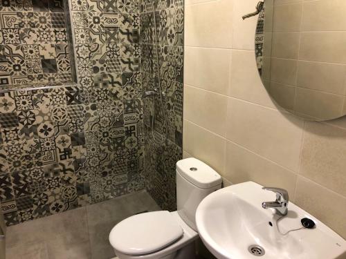 a bathroom with a toilet and a sink and a mirror at Piscina en Herrería 18 in Conil de la Frontera