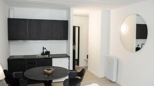 a kitchen with a table and chairs and a mirror at City Apartment - Perfect for two in Tåstrup
