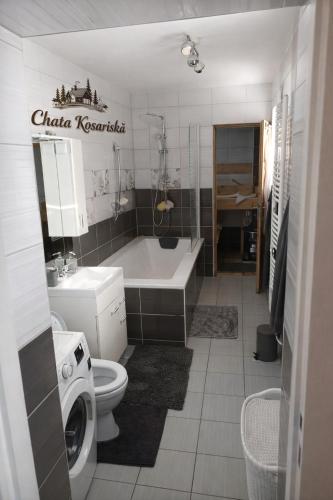 a bathroom with a tub and a toilet and a sink at Chata košaríska in Oščadnica