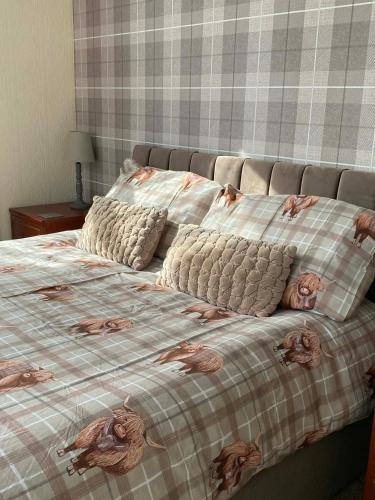 a bed with a blanket with a picture of animals on it at Strathwhillan House in Brodick