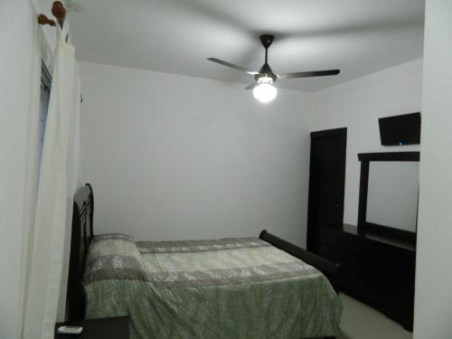 a bedroom with a bed and a ceiling fan at Residencial Vista Del Bosque in Santiago de los Caballeros