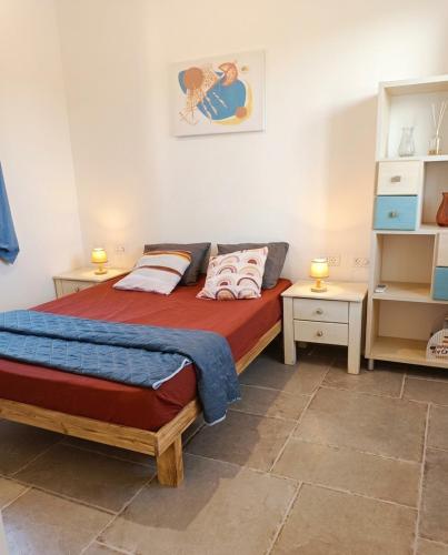 a bedroom with a bed and two night stands at פינה של נחת במצפה רמון in Mitzpe Ramon