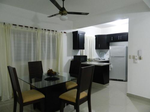 a kitchen and dining room with a table and chairs at Residencial Vista Del Bosque in Santiago de los Caballeros