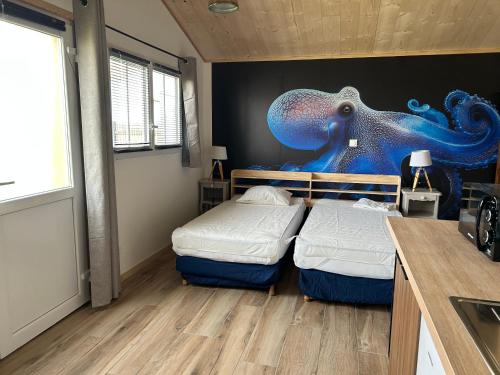 a room with two beds and a mural of an octopus at Sam Va in Dolus-d'Oléron
