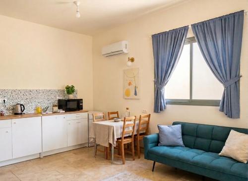 a living room with a blue couch and a table at פינה של נחת במצפה רמון in Mitzpe Ramon