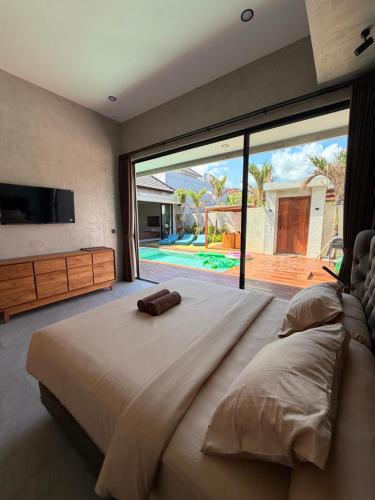 a bedroom with a large bed with a large window at Villa Donald in Canggu