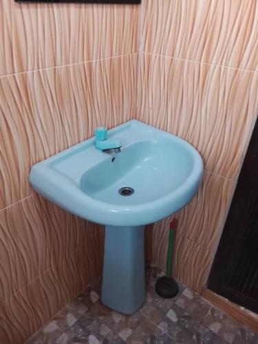 a white sink in a bathroom with a wooden wall at July 16th hotel and event centre in Alagbado