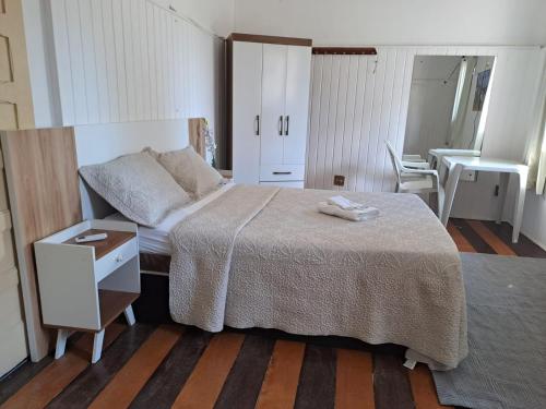 a bedroom with a bed and a dresser and a table at casa da Maria aconchegante in Belém