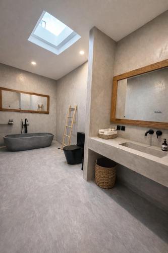 a bathroom with a tub and a sink and a mirror at Villa Donald in Canggu