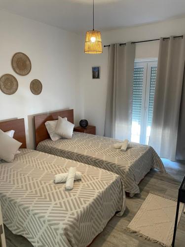 a bedroom with two beds with towels on them at Alojamento A Cascata in Vidigueira
