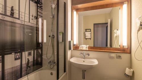 a bathroom with a sink and a shower at Campanile PRIME - Roissy - Aéroport Paris CDG in Roissy-en-France