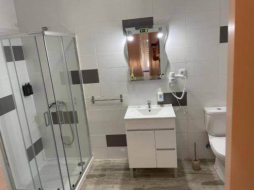 a bathroom with a shower and a sink and a toilet at Alojamento A Cascata in Vidigueira