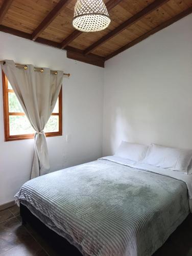 a bedroom with a bed and a window at Villa Belén in Guarne